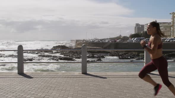 Sporty Caucasian woman exercising on a promenade on seaside