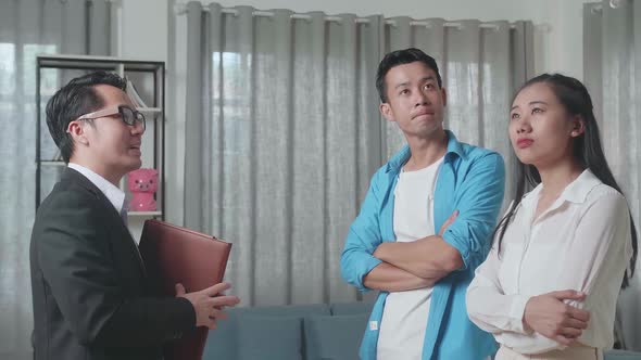Asian Couple Listens To A Real Estate Agent Explaining About The Inside Of The House For Sale