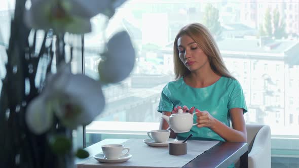 Gorgeous Woman Drinking Tea, Waiting for Someone at the Restaurant for Breakfast