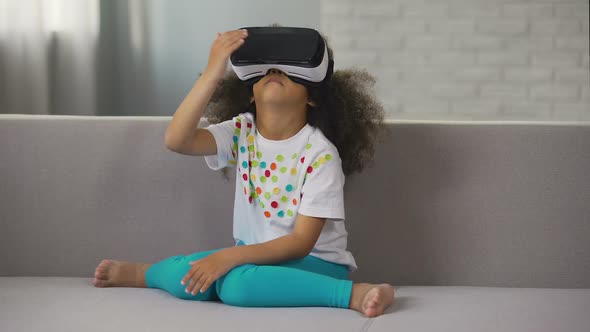 Afro-American Girl Wearing Virtual Reality Headset and Playing Game, Rest