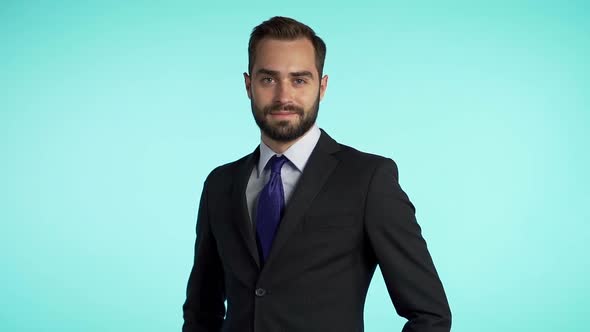 portrait of young successful confident businessman with beard isolated on blue studio