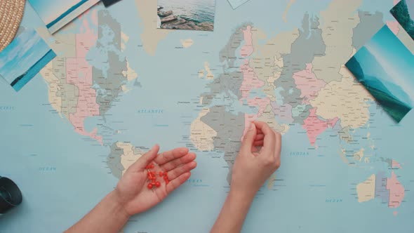 Woman Pushing Pins on World Map