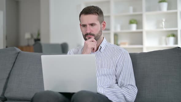 Professional Man Thinking and Working on Laptop at Home