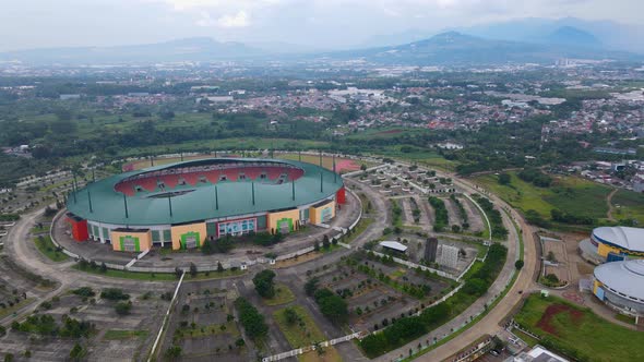 Aerial view of The largest stadium of Pakansari Stadium from drone. Indonesia. With noise cloud.