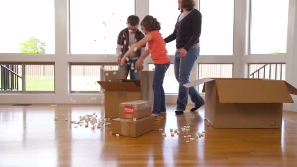 Family in new home unpacking boxes together