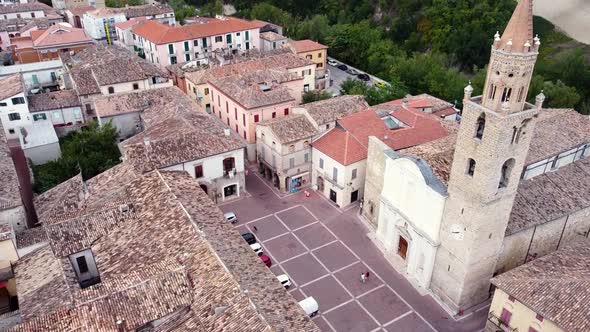 Aerial shot of a bell tower in a square of a small Italian town