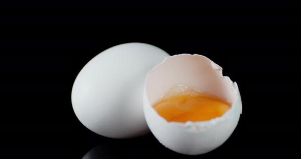 Broken and Whole Raw Eggs Slowly Rotate on the Table. 