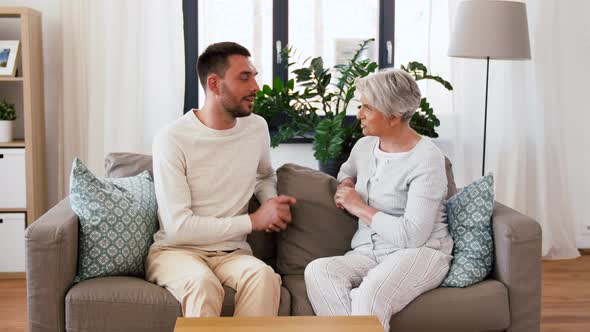 Senior Mother Talking To Adult Son at Home