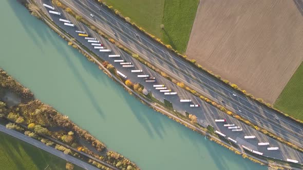 Top Down Aerial View of Highway Interstate Road with Fast Moving Traffic and Parking Lot with Parked