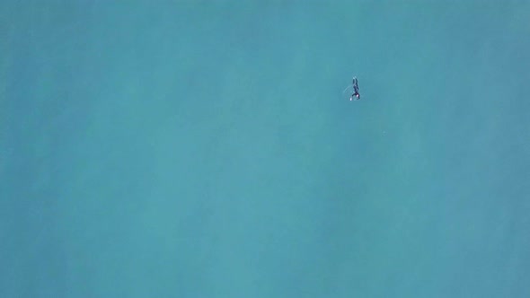 Man Swimming In The Azure Blue Sea Near The Beach Near Newquay, England, UK. - aerial