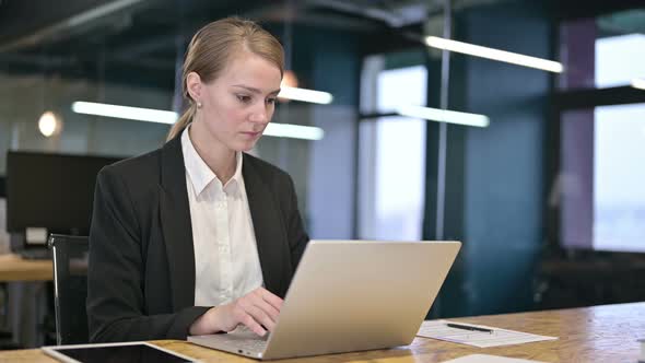 Ambitious Young Businesswoman Working on Laptop in Office