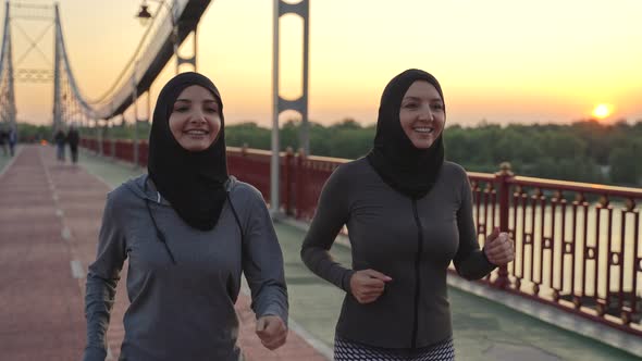 Active Smiling Arab Women in Hijabs on Jogging