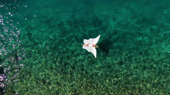 The girl is swimming in the sea. View from the air. Vacation and relaxation. Blue sea and coastline.