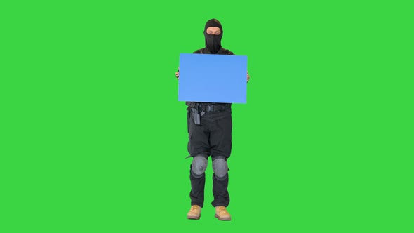 Riot Policeman Standing with a Blank Plakard on a Green Screen Chroma Key