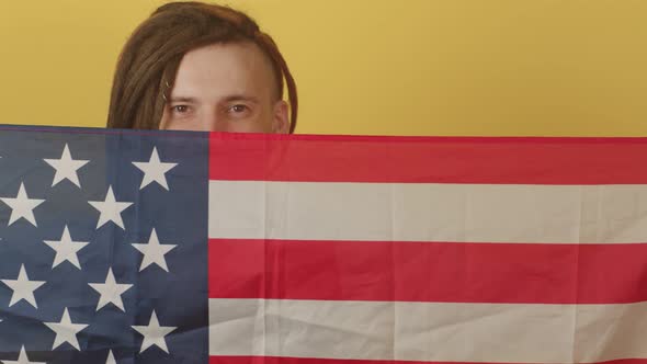 Young Man with American Flag on Yellow Background