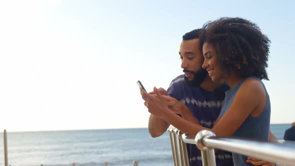 Couple using mobile phone in the beach