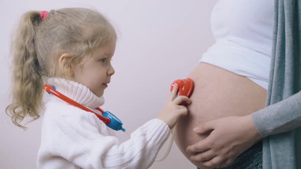 Girl with Ponytail Examines Pregnant Mommy Using Toys