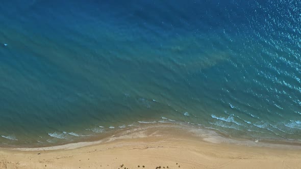 Top Aerial Drone View of a Deserted Beach and the Sea Calm Waves