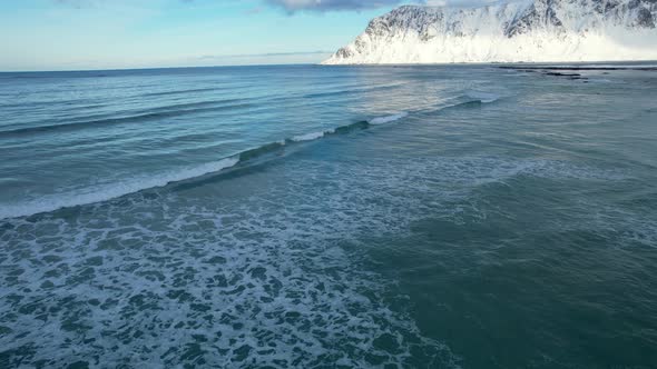 Waves rolling in on the shore of Flakstad Beach in Northern Norway, Lofoten Island, 4k, Aerial Shot.