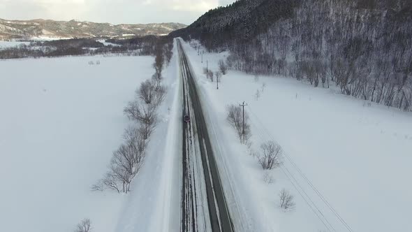 Drone's Camera Show Cars on Traffic During Snow. In Background Fields, Roads.