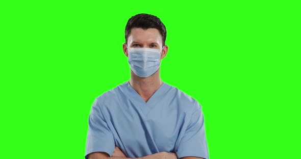 Caucasian male doctor wearing face mask on green screen background