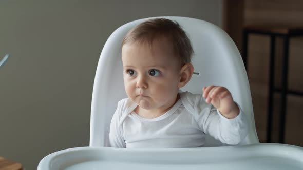 Video of baby girl waiting for lunch in high chair. Shot with RED helium camera in 8K.