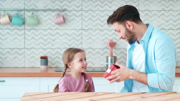 Little preschool girl giving gifts to her dad for father's day