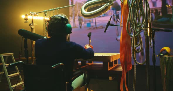 Mature Man on Wheelchair Creating Soundtrack for Robot Movie