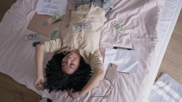 Top View of Excited Satisfied Young Woman Lying on Couch with Dollars Dancing