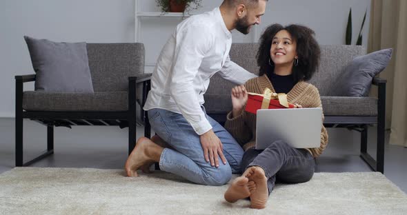 Mixed Race Business Woman Freelancer Working From Home Remotely Via Laptop Sitting on Floor