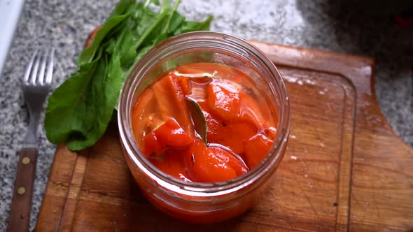 Top View Of Pickled Red Bell Peppers In A Glass Jar. overhead