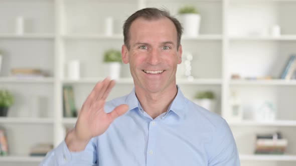 Portrait of Middle Aged Businessman Doing Video Chat and Waving