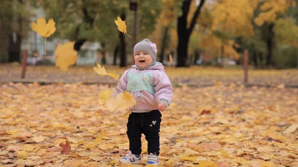 Autumn Leaves Falling Down on a Little Girl