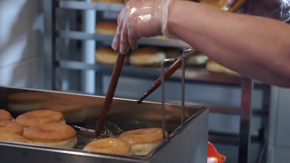The Chef Is Turning the Donuts with Sticks While Frying