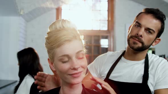 Male hairdresser styling a womans hair