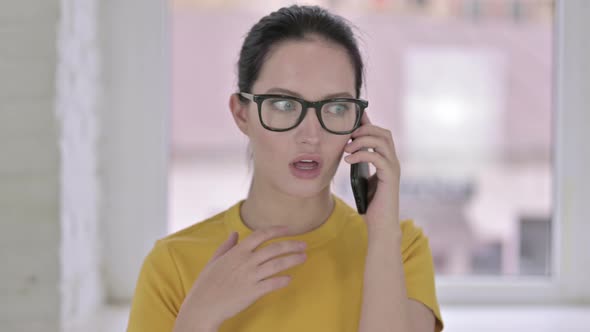 Portrait of Cheerful Young Female Designer Talking on Smartphone