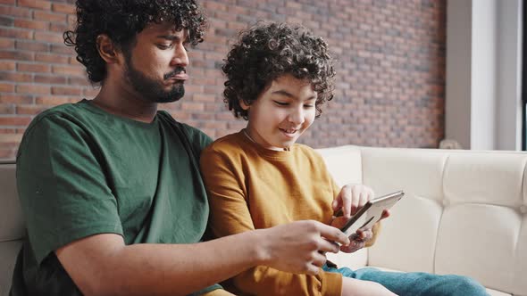 Father Shows Son Interesting Videos About Animals on Tablet