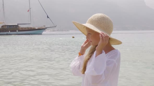 Portrait Girl Teenager in Straw Hat Watching on Sea and Ship Background