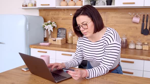 Online banking with laptop. Woman doing online shopping with credit card while at home