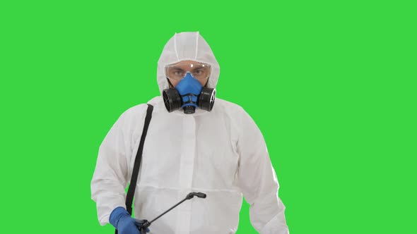 Disinfectant Walking with Antiviral Liquid Tank Looking To Camera on a Green Screen, Chroma Key