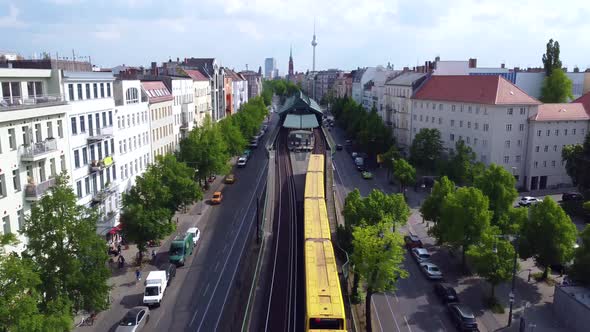 Yellow subway goes into the elevated train station Eberswalder. Marvelous aerial view flight track f