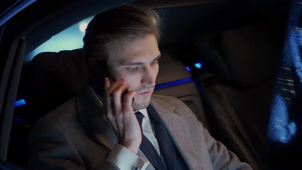 Handheld Businessman Sitting in a Moving Car Talking on a Mobile Phone and Using Laptop Young Top