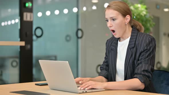 Young Businesswoman Working on Laptop and Feeling Shocked in Office