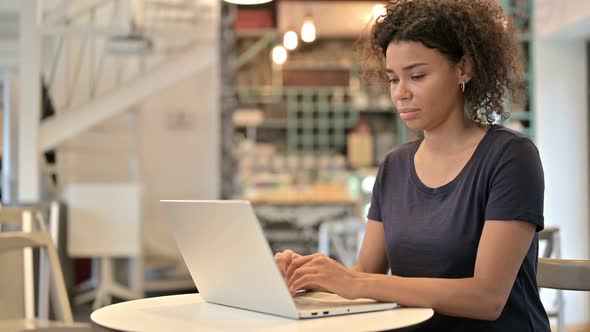 Young African Woman with Laptop Doing Thumbs Up 