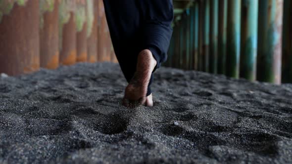 Woman is Walking Over Black Sand and Dancing on Beach Under Pier