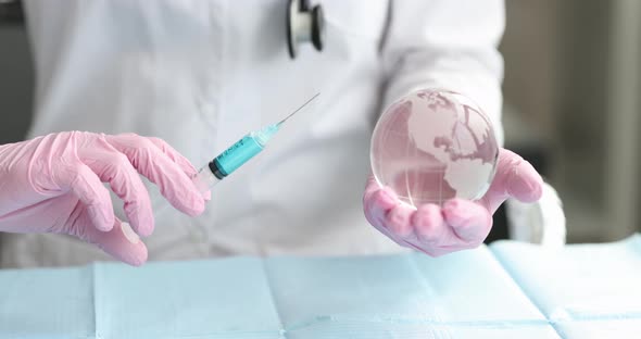 Doctor Virologist Holds Glass Globe and Syringe with Vaccine