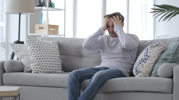 Adult Man Sitting on Couch in Anger, Feeling Frustrated