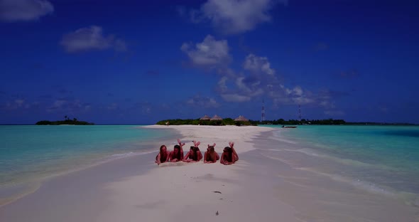 Young smiling ladies on holiday by the sea on the beach on summer white sand and blue 4K background