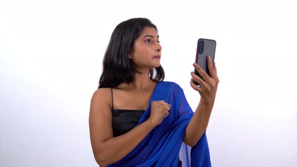 Stressed and angry Indian young adult in saree talking to someone on a video call