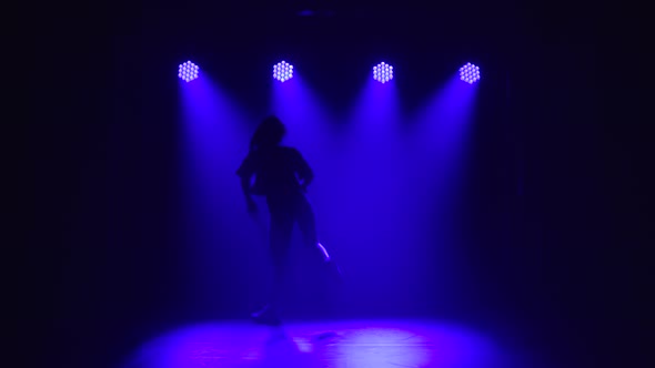 Jazz Funk Performed By a Young Girl in a Tracksuit. Silhouette on a Dark Studio Background with Blue